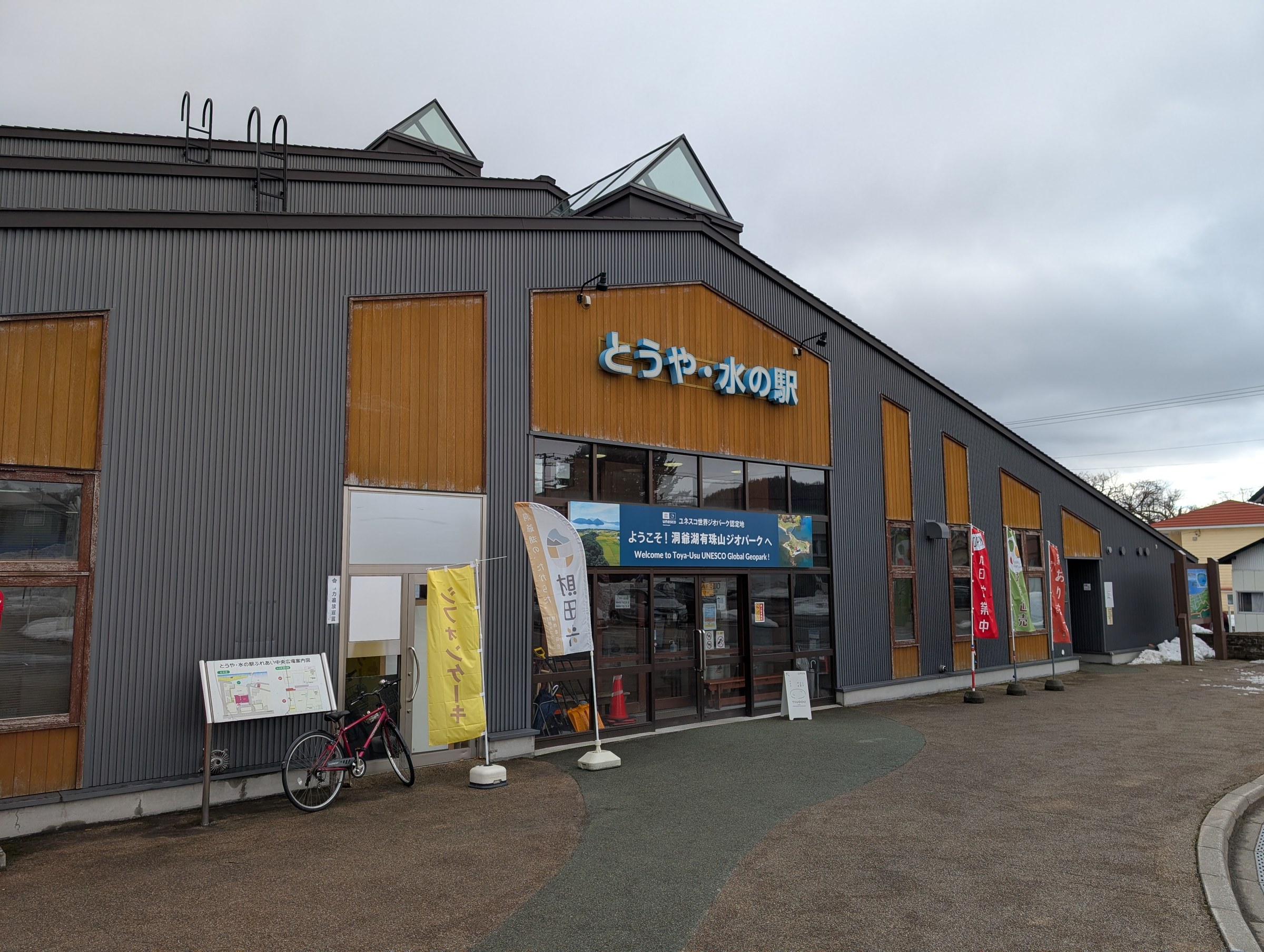 とうや水の駅の外観。グレーと木の外壁、正面入口に「とうや・水の駅」の看板