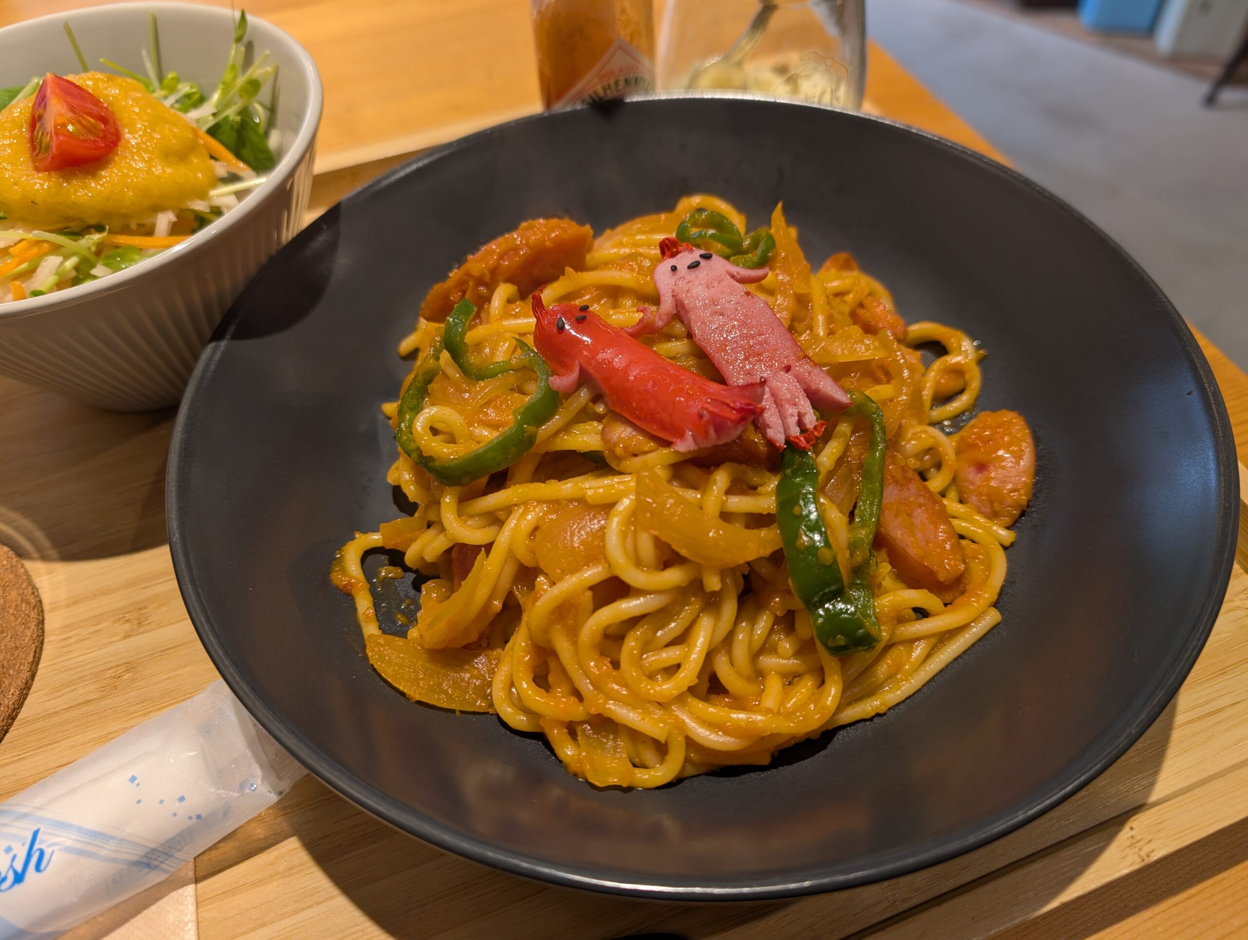 THE LAMP ROOM CAFEのナポリタン。黒い皿に盛り付けられた太麺にタコさんウインナーが添えられている