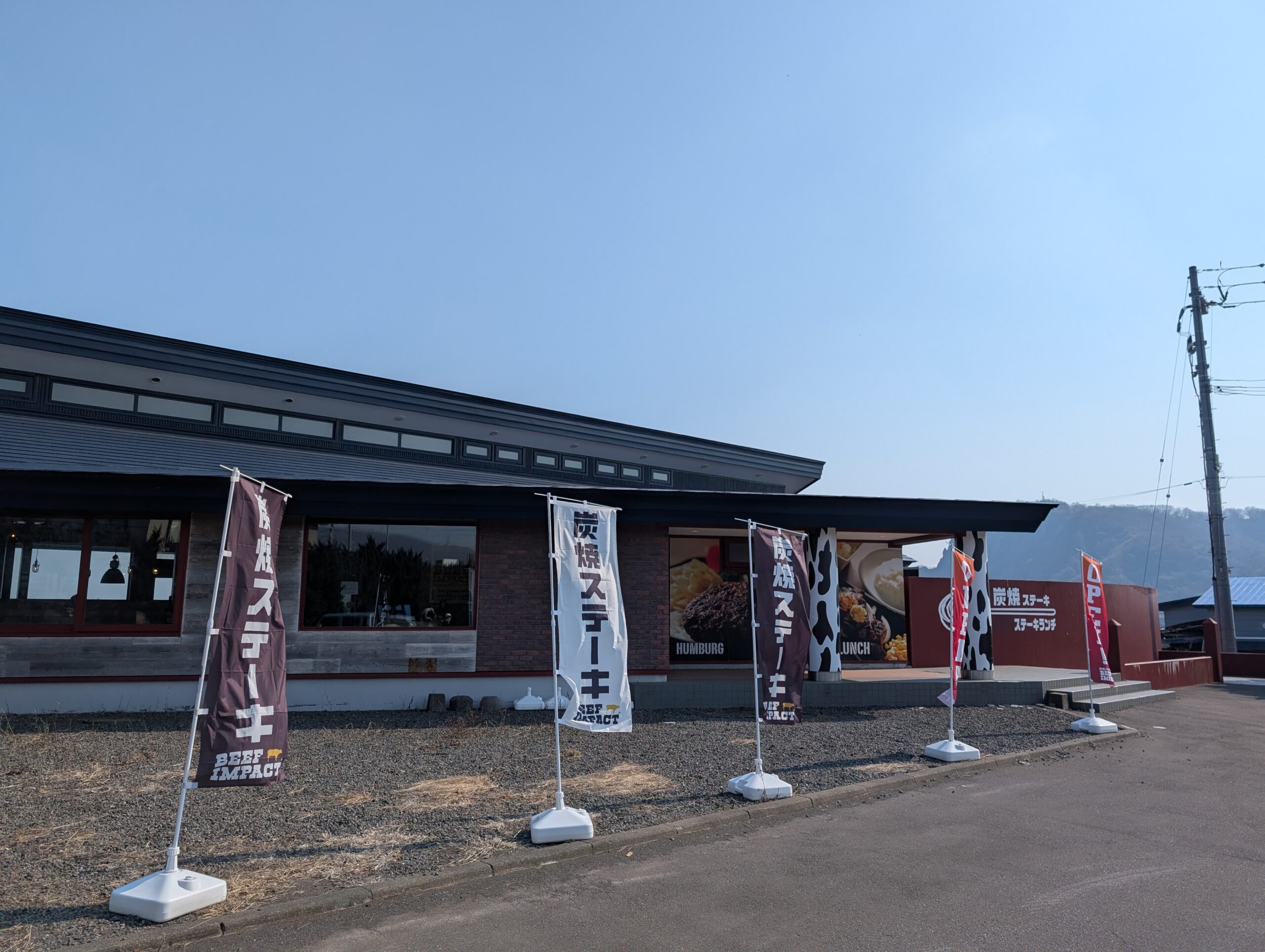 ビーフインパクト室蘭店の外観。炭焼ステーキののぼりが並ぶ