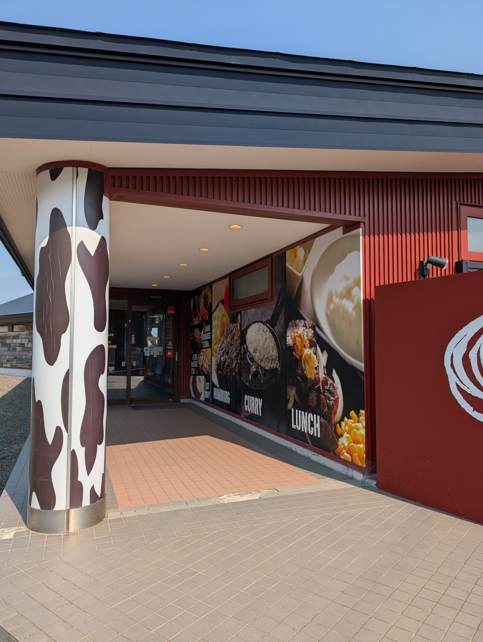 ビーフインパクト室蘭店の入口。牛柄の柱とメニュー写真