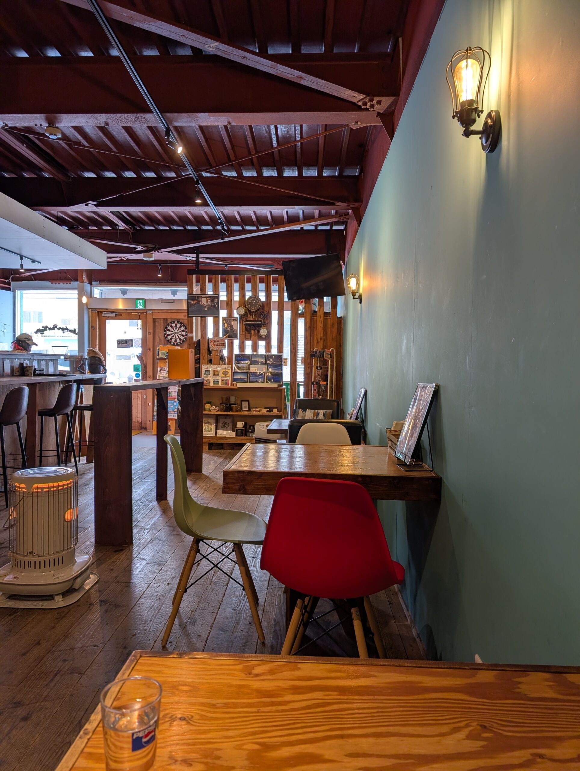 Sunday Pool Coffeeの店内。グリーンの壁面にカラフルな椅子、ウォールランプ