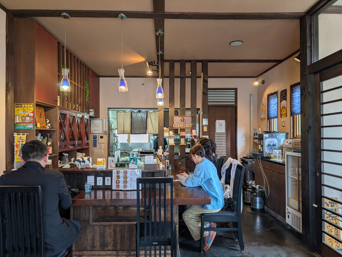 アペコロ店内。ダークウッドのカウンターと青いペンダントライトが特徴的な和の空間