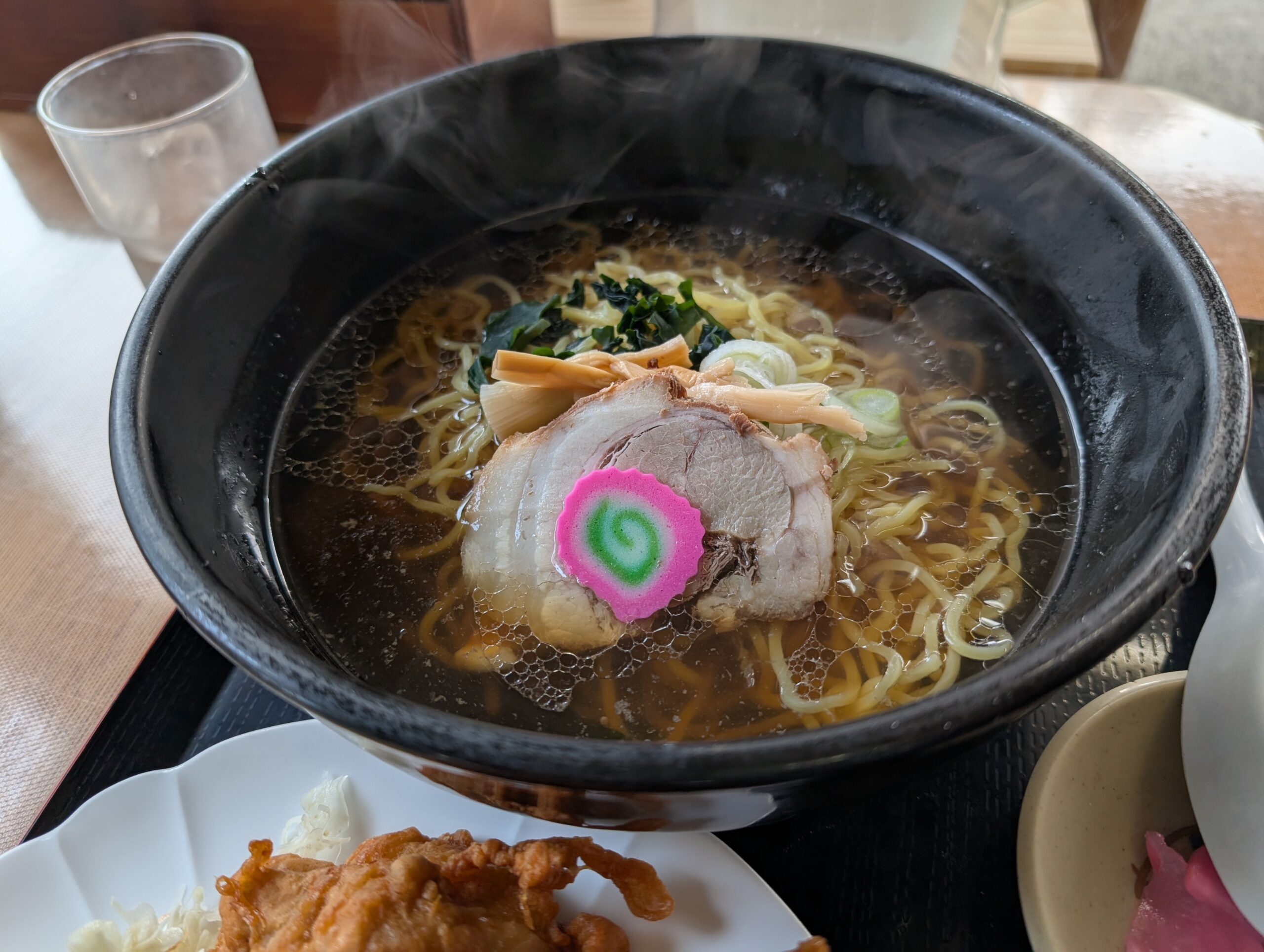 醤油ラーメンのアップ。チャーシュー、なると、メンマ、ネギ、わかめが乗っている