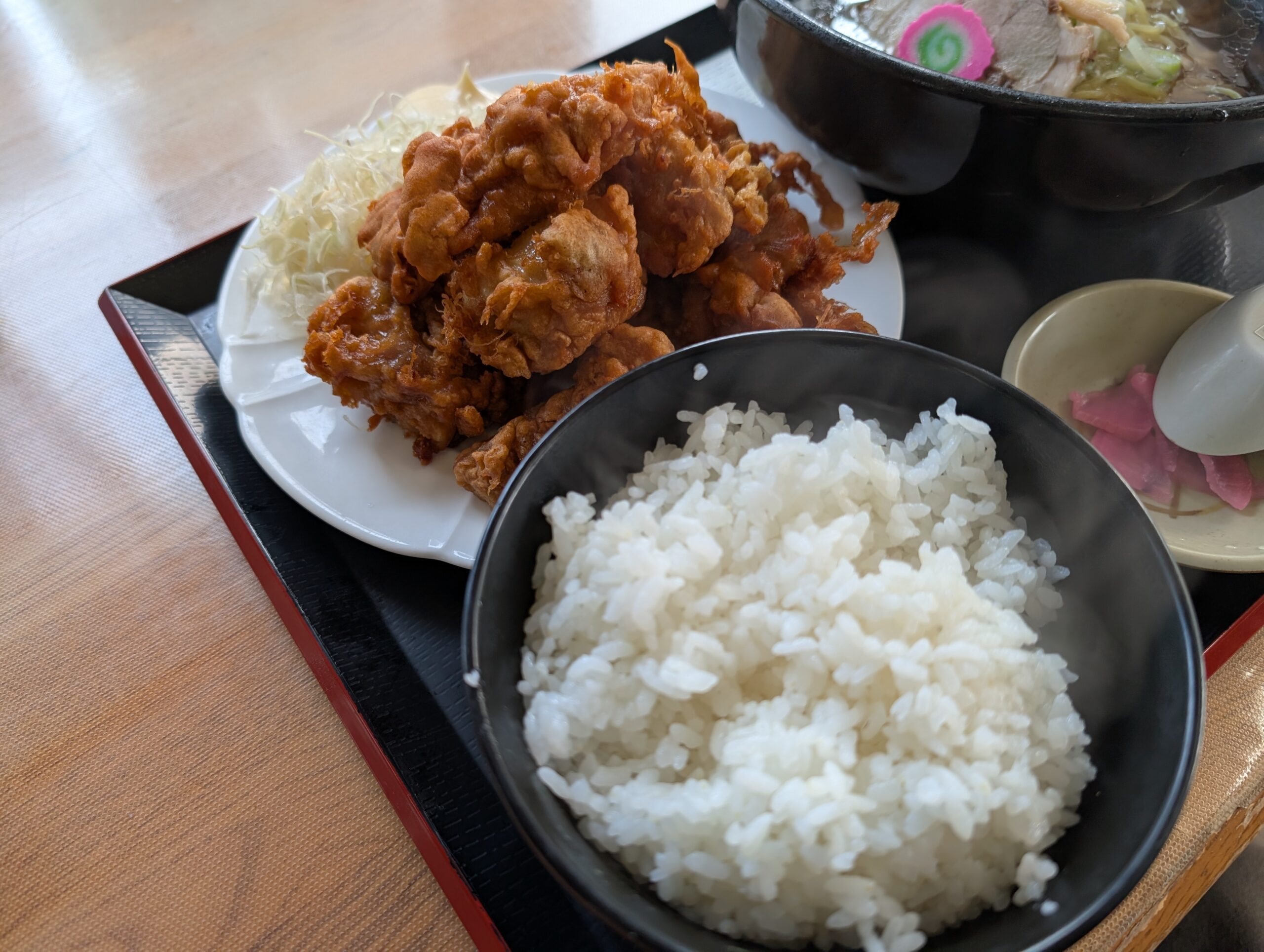 山盛りのザンギとご飯のアップ。キャベツの千切りを添えて皿に盛られている