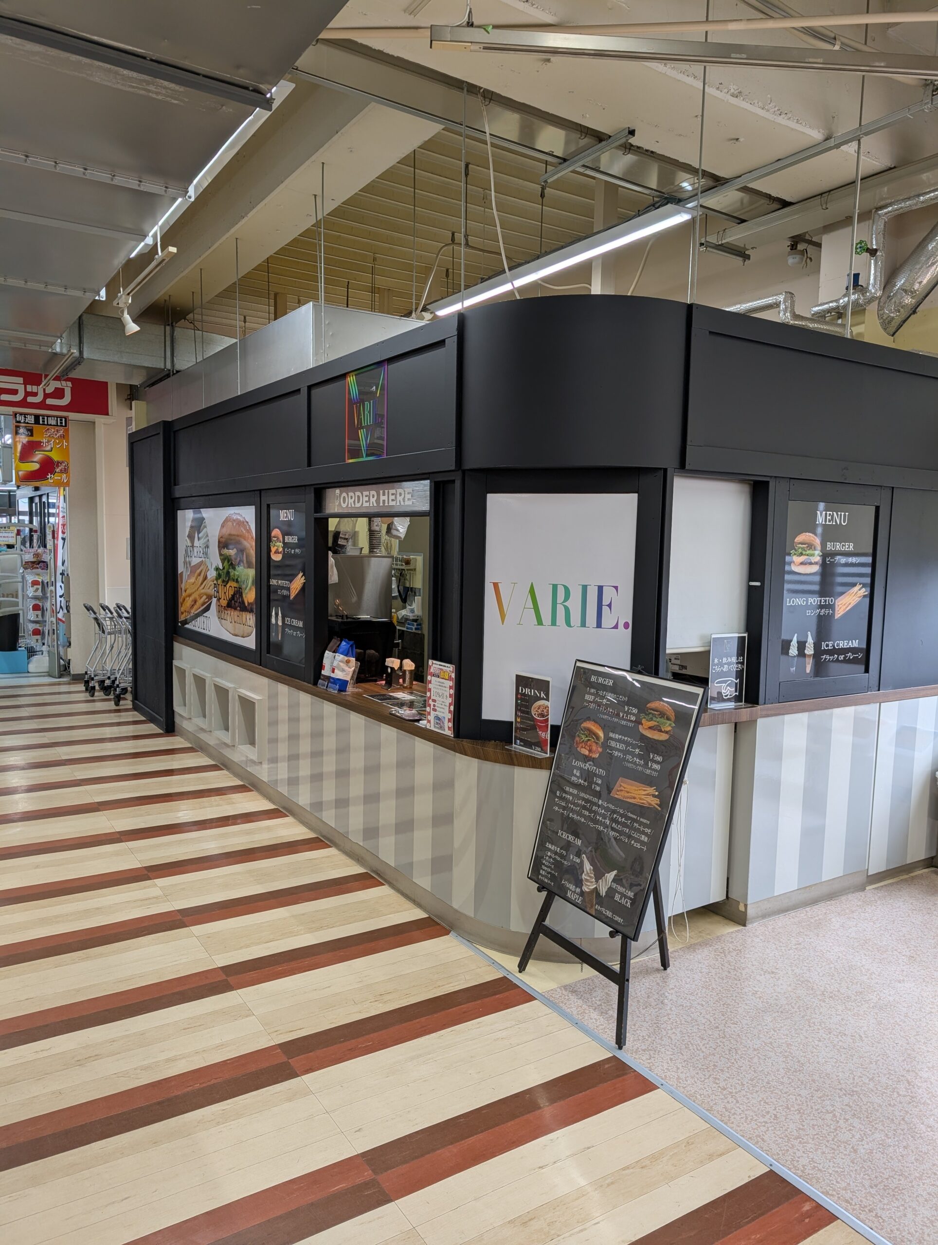 VARIE. アークス伊達店の外観。黒い壁面にカラフルなロゴ